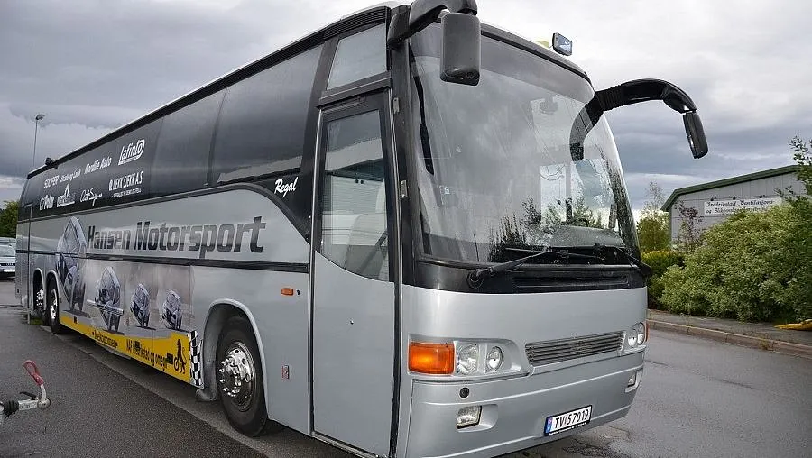 Fronten på en grå og svart turbuss fra "Hansen Motorsport" med vindusviskere hevet