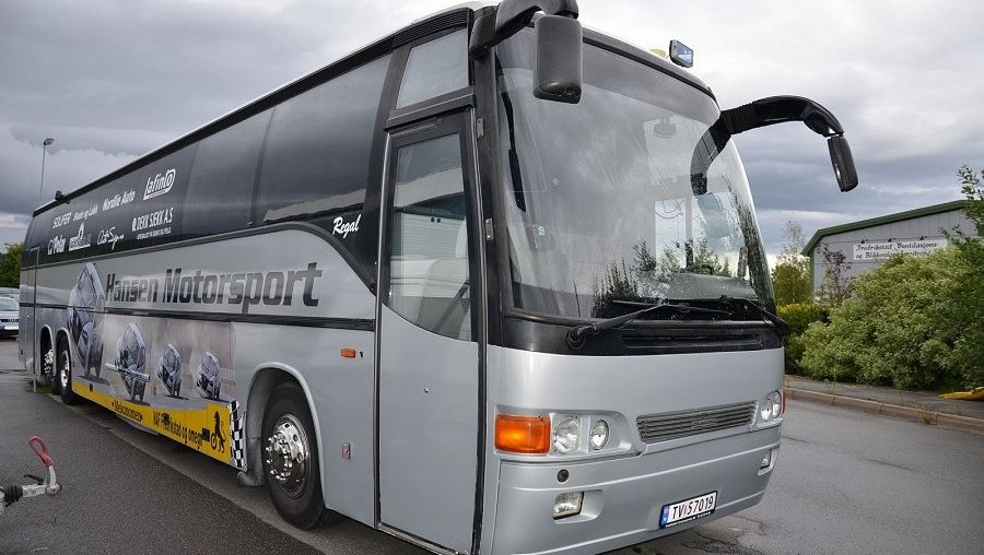 Fronten på en grå og svart turbuss fra "Hansen Motorsport" med vindusviskere hevet