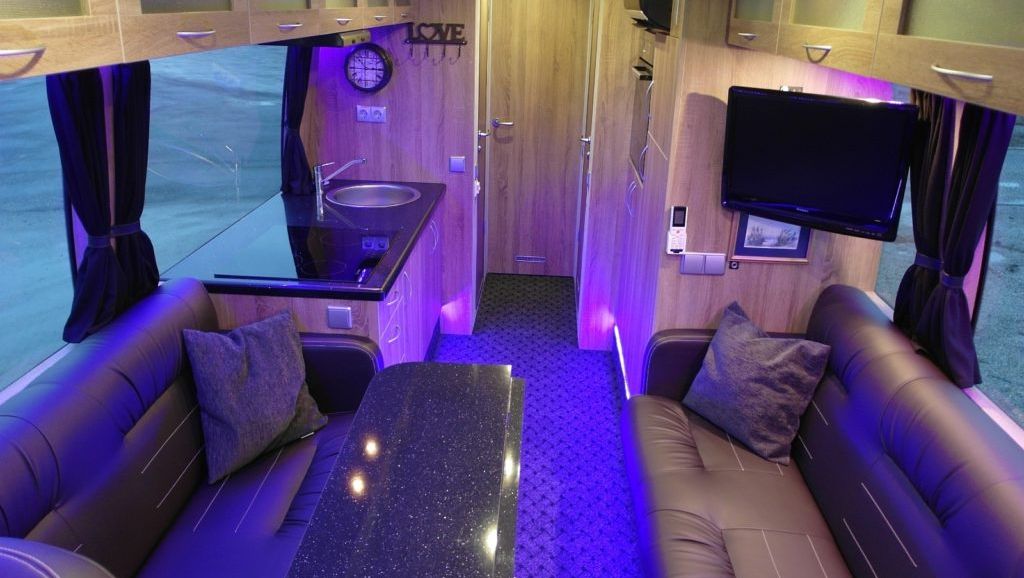 Lounge og kjøkkenområde opplyst av lilla led lys