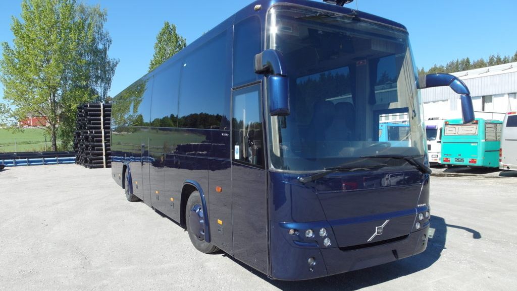 Mørkeblå buss med sotete ruter sett skrått fra front