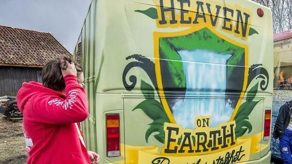 Bakside av lys gul russebuss med teksten «Heaven on Earth» og illustrasjon av vannfall.